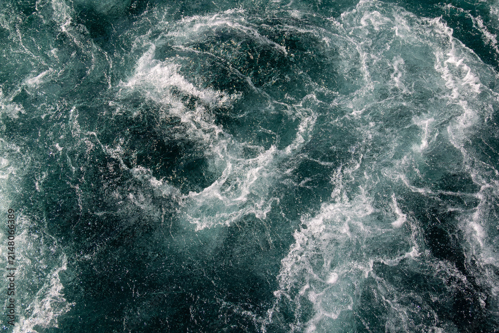 Fototapeta premium Dark turquoise swirling frothy water close-up. Pristine clear Waikato River, New Zealand flowing from Lake Taupō Control Gates, supporting downstream hydroelectric generation.