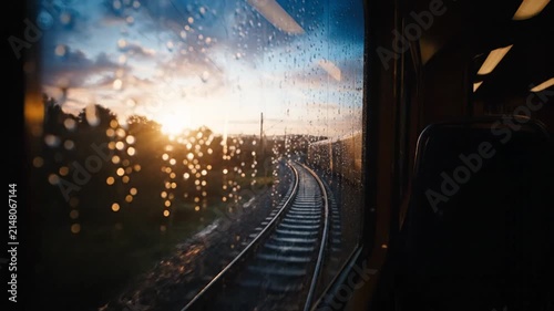 Train tracks journey through evening landscape reflecting sunset light