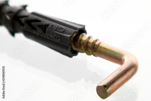 Close-up of a metal wall anchor with plastic expansion plug isolated on a white background. Used in construction, renovation, carpentry, and DIY home improvement projects.