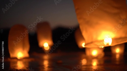 Floating lanterns illuminate the night sky with warm ethereal glow