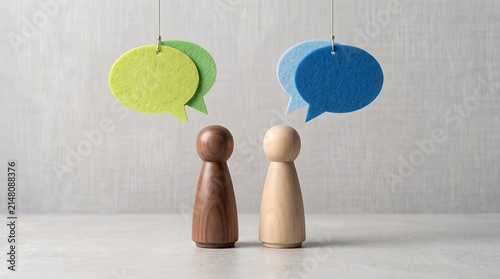 Diversity communication concept showing two wooden figures with hanging speech bubbles representing corporate dialogue