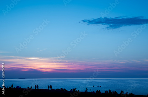 Sunset over the Sea with Silhouetted People on the Beach Evening Seascape