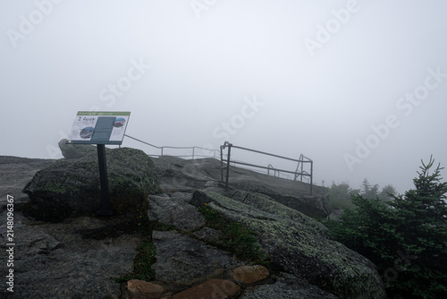 Принти на полотні Sign marks a viewpoint at a rocky ledge in foggy weather