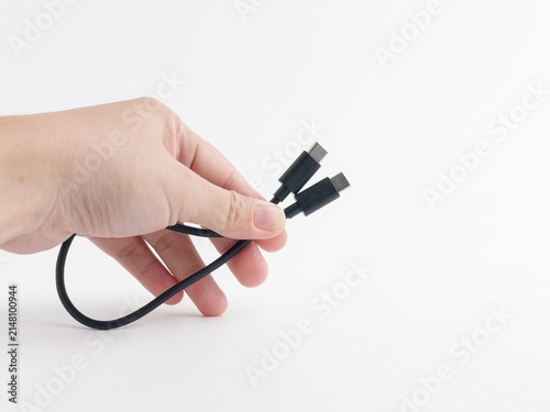 Person hand holding black USB type C charging and data cable isolated on white background