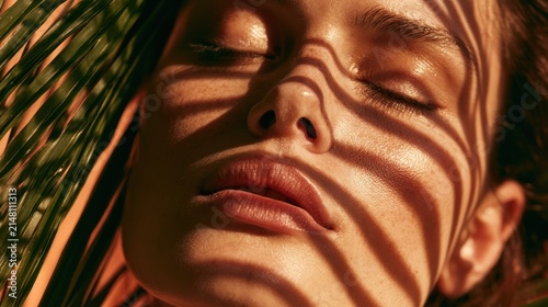Close up of womans face with palm leaf shadows