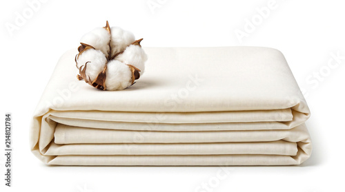 Folded piece of raw cotton fabric with a cotton boll isolated on white background