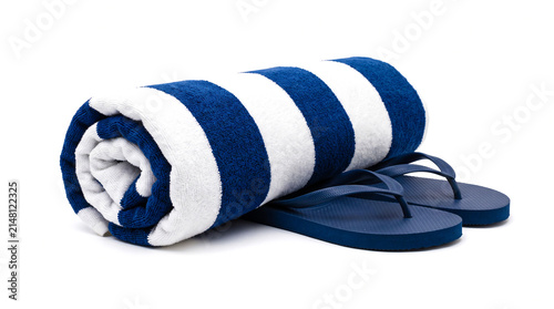 Rolled blue and white striped beach towel with flip flops, isolated on white background