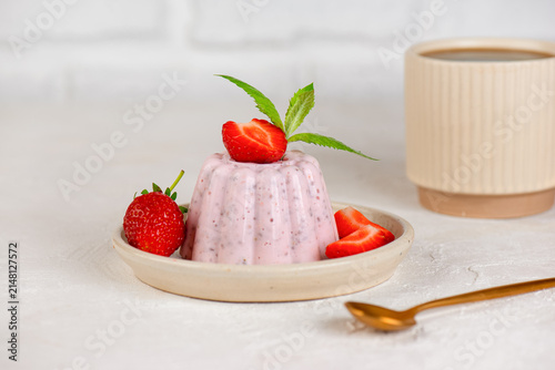 Fresh strawberry chia jelly dessert with healthy ingredients and cup of tea.