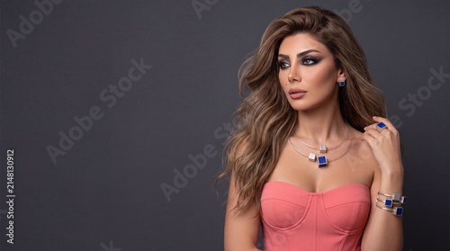 Fashion woman wearing luxury modern lapis lazuli cube silver necklace set and pink corset on dark background