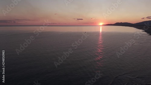 Golden hour sun setting over a tranquil ocean bay