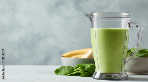 Healthy green smoothie in a blender with spinach and bananas, ready to drink