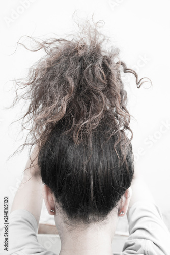 Woman drying her long brown hair in the morning, rear view.