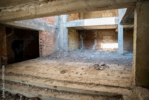 Fotografía Abandoned building interior with exposed brick walls and concrete structures