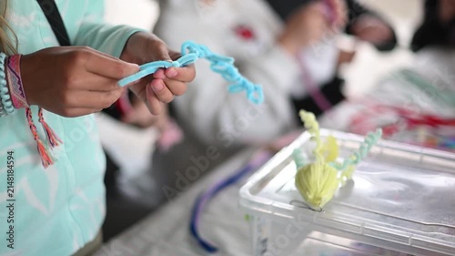 Child's hands twisting pipe cleaner for diy art project during a creative workshop close up of handmade crafting