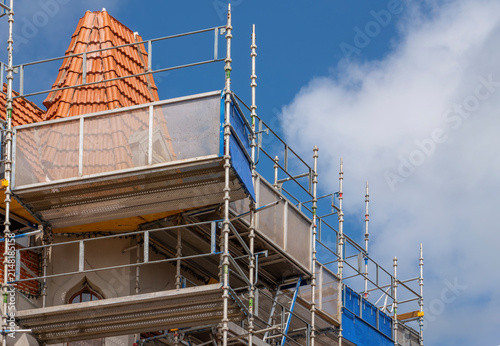 Renovation with scaffolding and tiled structure on historic building