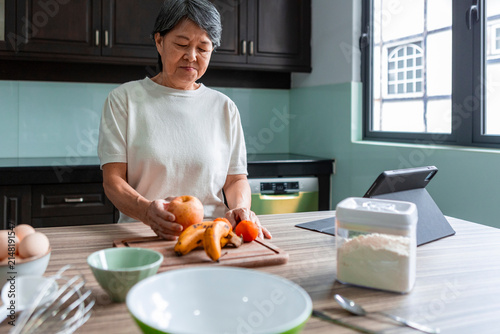 Asian woman prepare fruit in modern home kitchen
