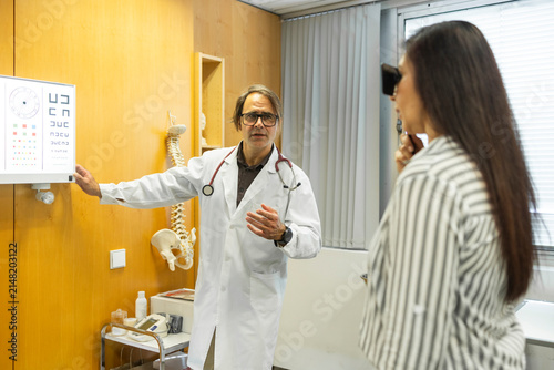 Doctor explain eye chart to patient at medical clinic