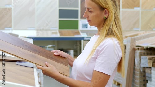 Woman Comparing Laminate Flooring Panels in Home Improvement Store