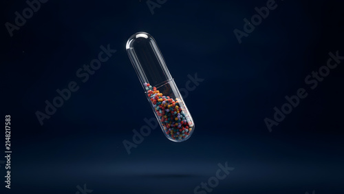 A transparent medical pill capsule filled with colorful small spheres