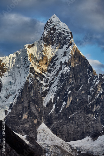 southeast face of Jirishanca reveals its full, imposing grandeur in Peru's Cordillera Huayhuash. Sheer walls of rock and ice rise in near-vertical lines toward a serrated summit, sculpted by centuries