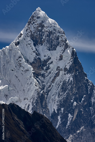 southeast face of Jirishanca reveals its full, imposing grandeur in Peru's Cordillera Huayhuash. Sheer walls of rock and ice rise in near-vertical lines toward a serrated summit, sculpted by centuries