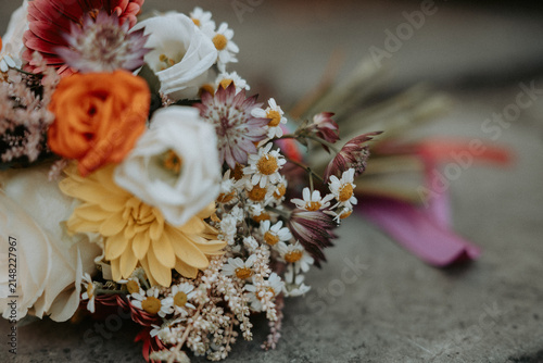 Bouquet de mariée coloré posé sur des marches en pierre avant la cérémonie