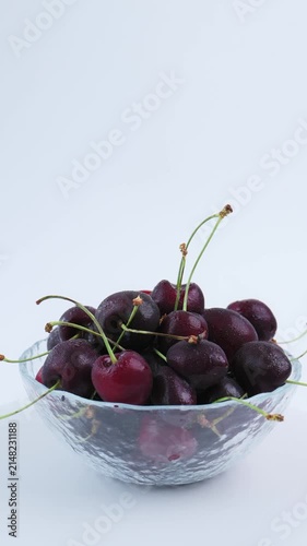Organic dark cherry arranged in transparent glass bowl with clean white backdrop, natural cherry appearance emphasizes wholesome produce, healthy nutrition, premium seasonal fruit presentation. 4k 