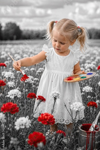 Child painting flowers red in grayscale field