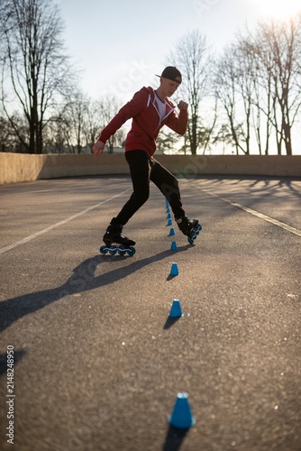 Canvastavla Young man in a red hoodie practicing freestyle rollerblading tricks