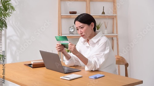 通帳を持って悩む女性