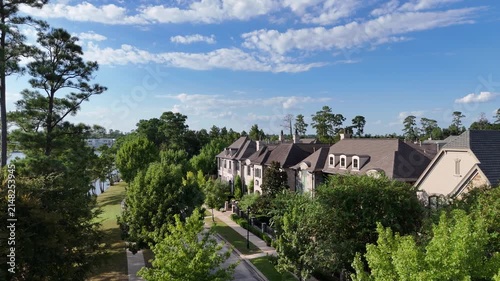 Aerial view of large mansion houses with swimming pool, in affluent neighborhood by Woodlands lake, Houston, Texas, expensive suburban homes surrounding by lush green trees, USA