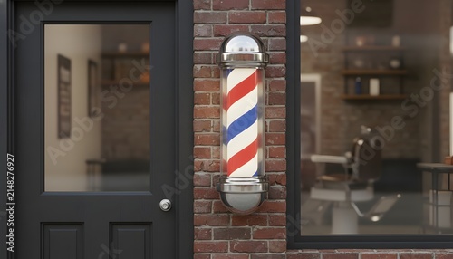 Classic barbershop pole mounted outside next to a black door on a brick wall for traditional male grooming business concept