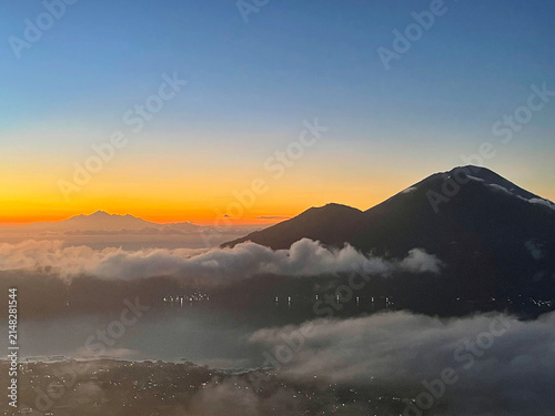 Dawn view from Mount Batur to neighboring volcano Agung and lake below, Bali