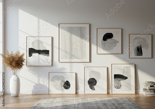 A gallery wall arrangement featuring several framed abstract artworks in a bright interior space with natural light ,office ,decor ,picture