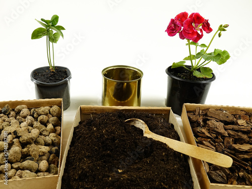 Flower potting mix, drainage materials, bark are on a  white background. Houseplant repotting materials. Flower transplanting.
