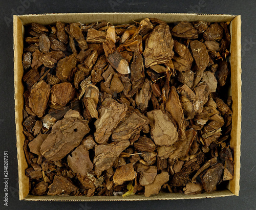Heap of the potting barks in a cardboard box, top view, natural background