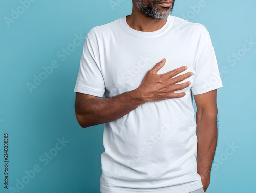 Man touching chest heart pain discomfort chest pressure male torso white t shirt beard stubble blue background adult man healthcare symptom chest discomfort early heartache cardiology medical