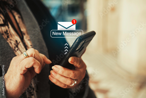 Mature woman checking smartphone notification with new message alert icon. Digital communication, technology in everyday life, and senior smartphone usage concept.