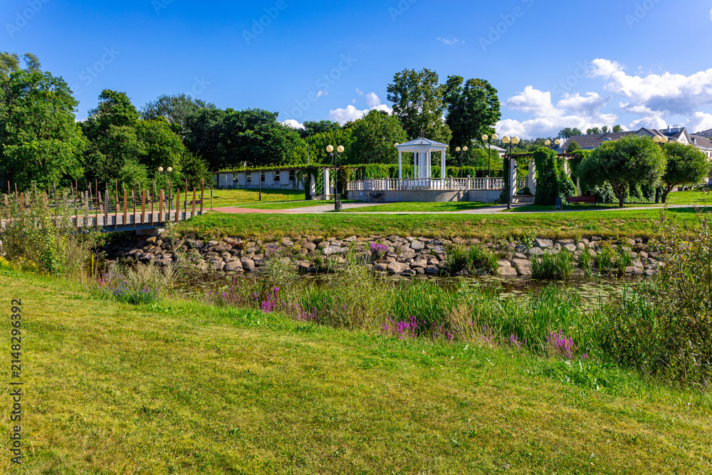 Obraz premium White pavilion and wooden bridge in public seaside park landscape