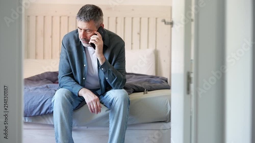 Stressed middle-aged man receiving bad news on the phone
