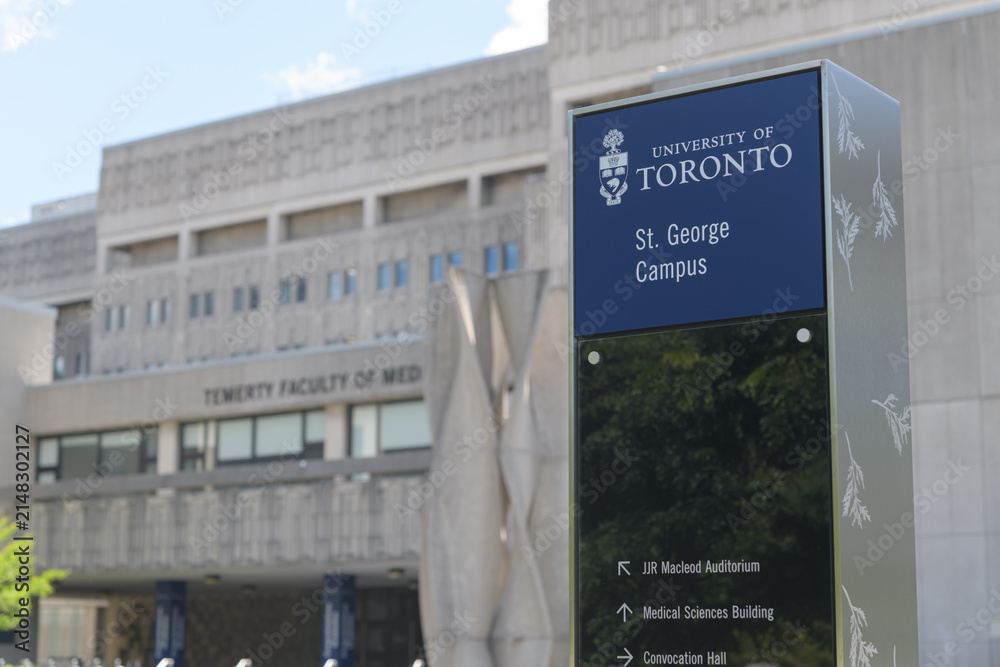 Fototapeta premium wayfinding marker on the St George Campus of the University of Toronto with a defocused view of Temerty Faculty of Medicine (Medical Sciences Building, MSB) 1 King’s College Circle