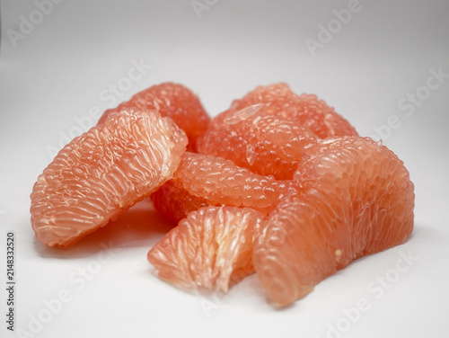 Heap of peeled pink pomelo fruit pulp full of antioxidants and vitamin C on white