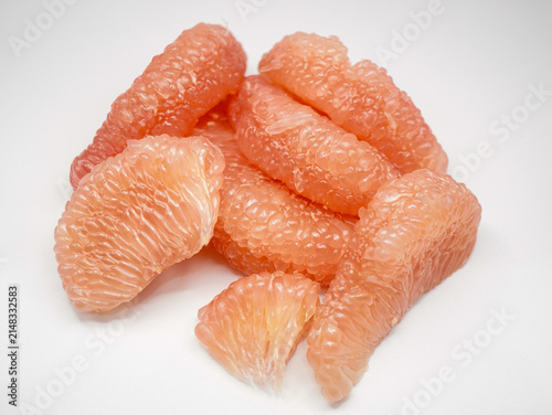 Top-down view of vibrant red pomelo fruit segments isolated on a pure white background