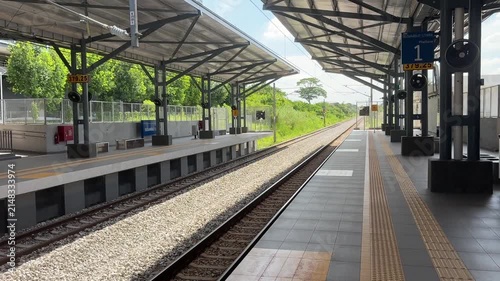 A lonely and quiet railway station platform in morning light, feeling deserted and empty.