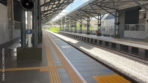 A lonely and quiet railway station platform in morning light, feeling deserted and empty.