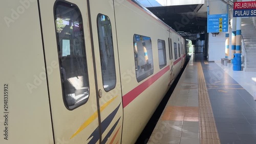 Malaysian KTM Komuter electric train arriving at the station platform, public transportation.