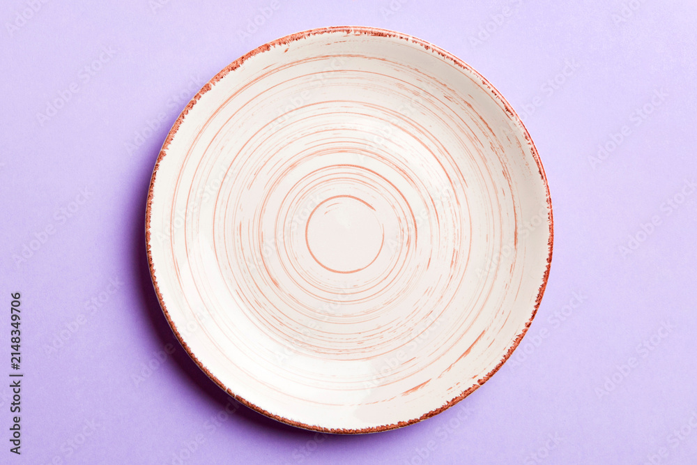 Fototapeta premium Top view of isolated of colored background empty round beige plate for food. Empty dish with space for your design