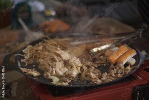 фотографія Savory meat, fresh vegetables, and tasty noodles sizzling on a hot plate during