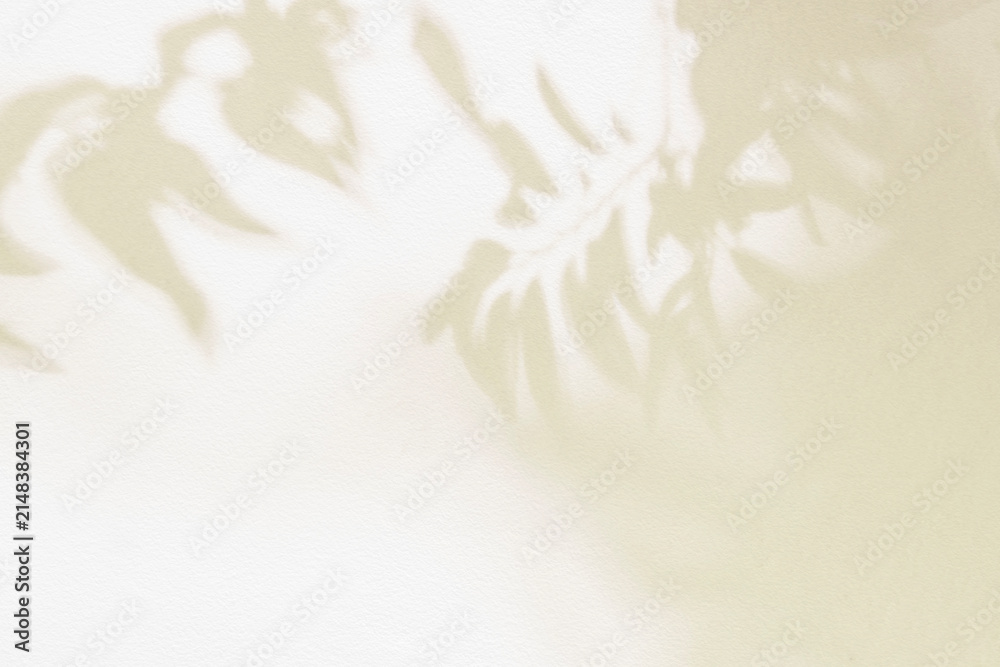 Naklejka premium Leaf shadow and light beige background. Nature tropical leaves plant and tree branch shade with sunlight on wall texture for background wallpaper and design, shadow overlay effect