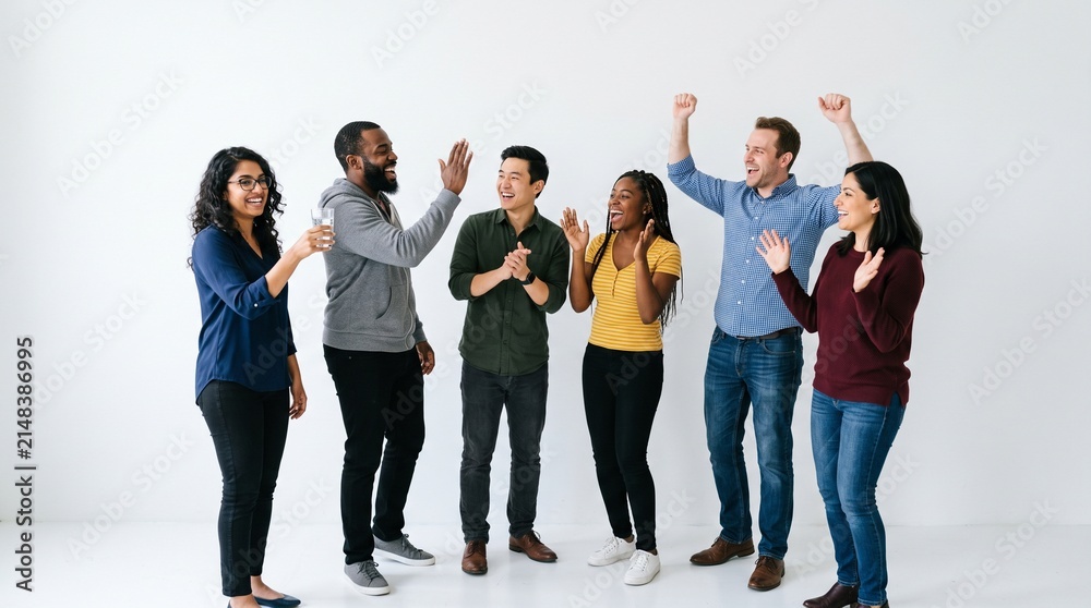 Obraz premium Diverse Team Celebrating Success: A group of happy and diverse individuals are celebrating success with a high five, creating a positive and energetic atmosphere.